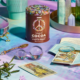 Magick Cocoa displayed with crystals, herbs, and tarot cards. 