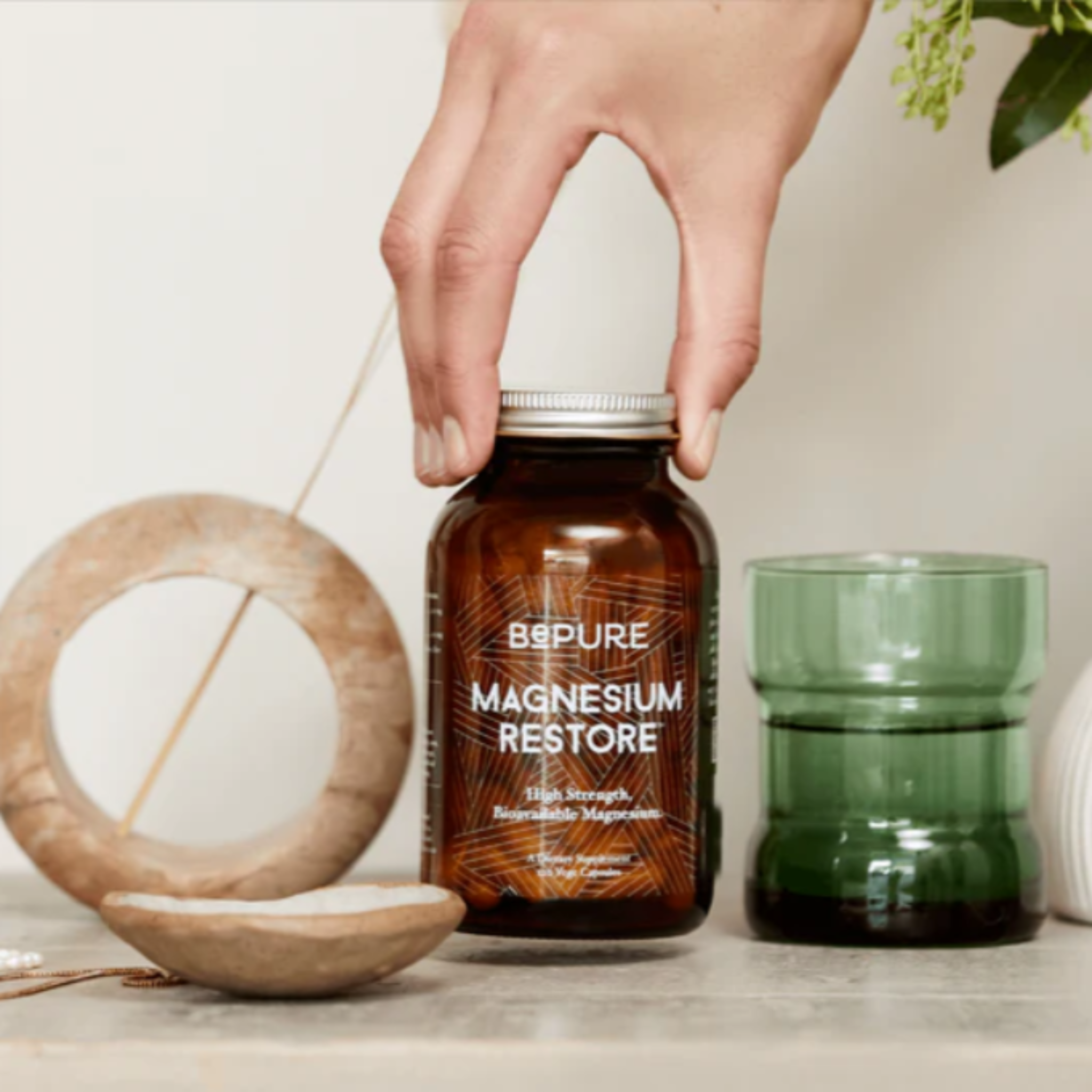 Bottle of Bepure Magnesium Restore held by a hand with a minimal background