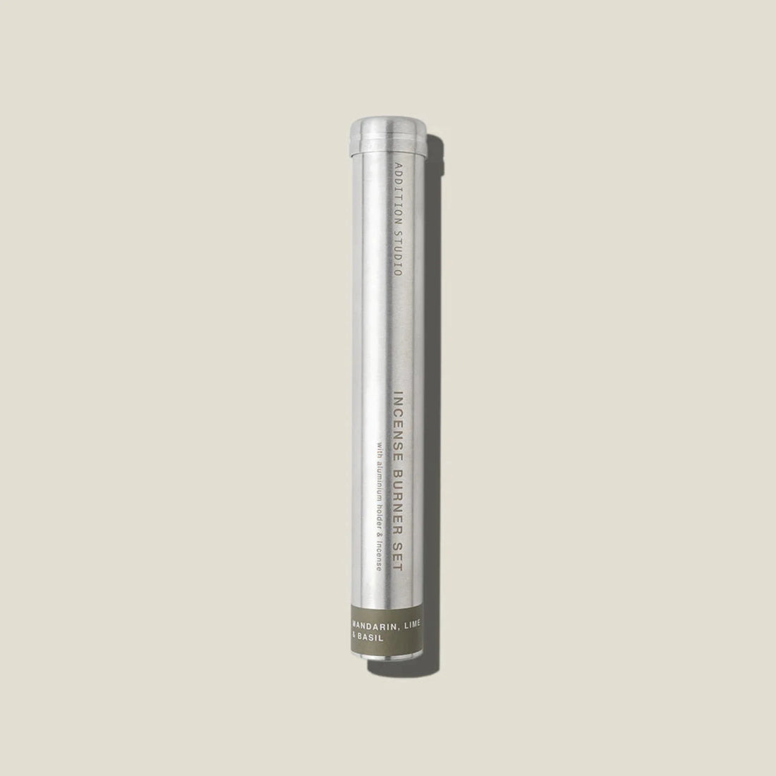 An aluminium tube containing mandarin, lime and basil incense sticks and holder. 