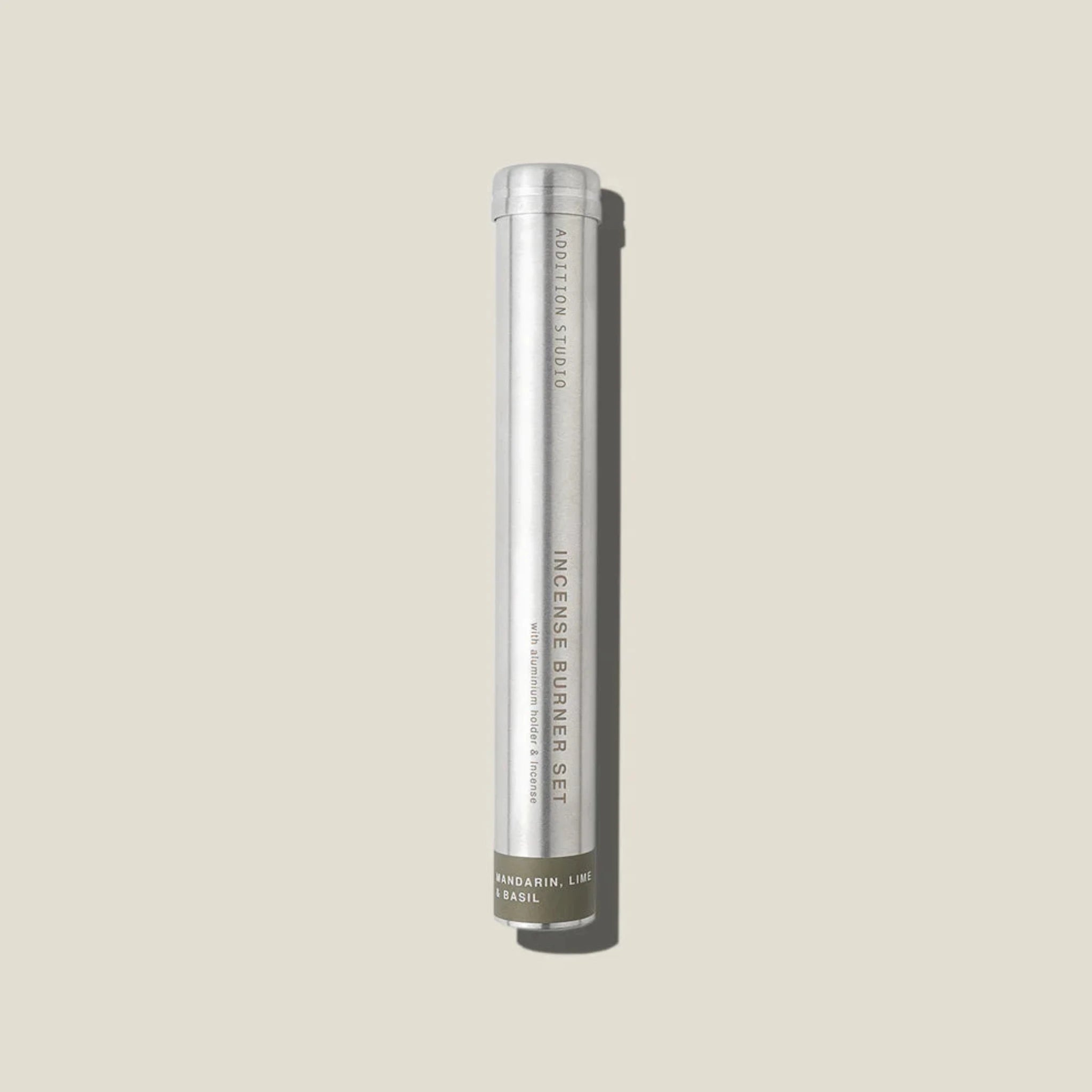 An aluminium tube containing mandarin, lime and basil incense sticks and holder. 