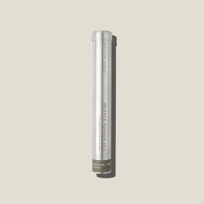An aluminium tube containing mandarin, lime and basil incense sticks and holder. 