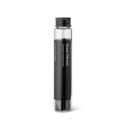 A glass vial of black incense sticks with the Ocean Odyssey fragrance by Studio Milligram.