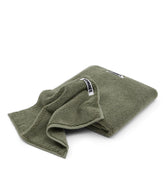 Green towel with a brand label on a white background