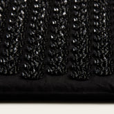 Close-up of a black textured fabric with small diamond patterns.