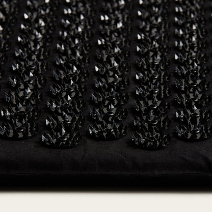 Close-up of a black textured fabric with small diamond patterns.