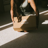 Person holding a cardboard box with &