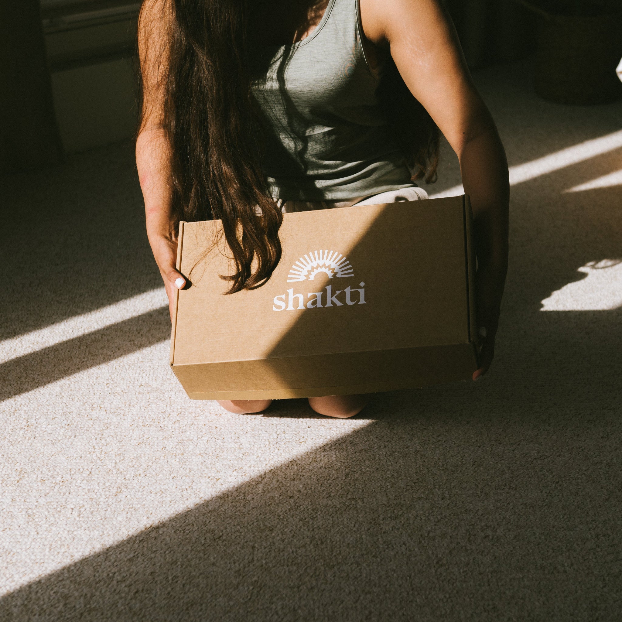 Person holding a cardboard box with &