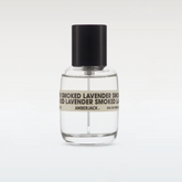 Clear perfume bottle with black cap and label on a white background