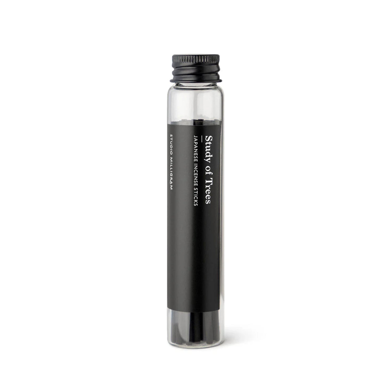A glass vial of black incense sticks with the Study of Trees fragrance by Studio Milligram.
