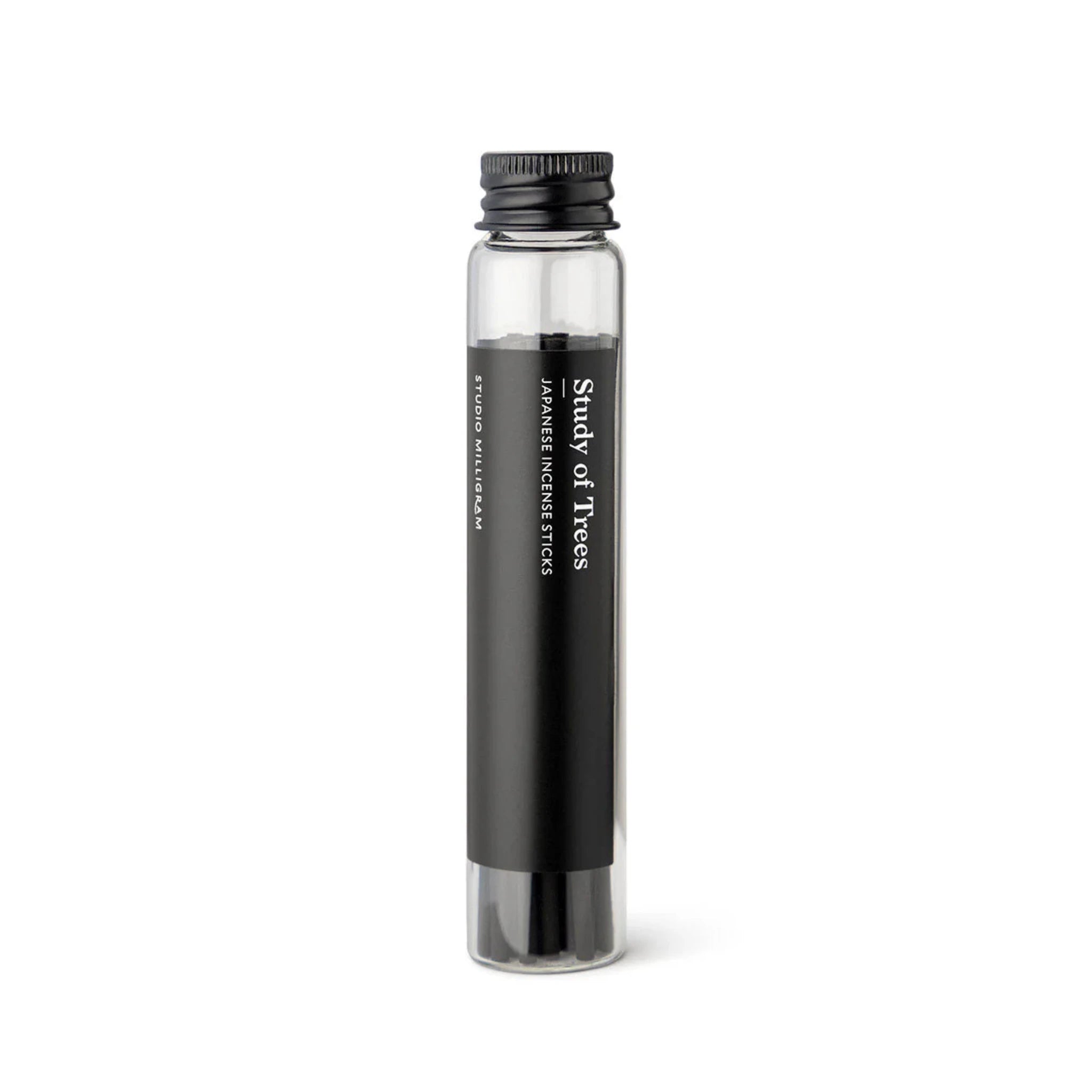 A glass vial of black incense sticks with the Study of Trees fragrance by Studio Milligram.