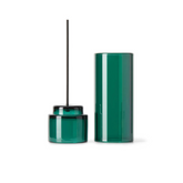Green glass incense holder with a single stick on a white background