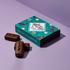 Chocolate confections with a decorative box on a light purple background