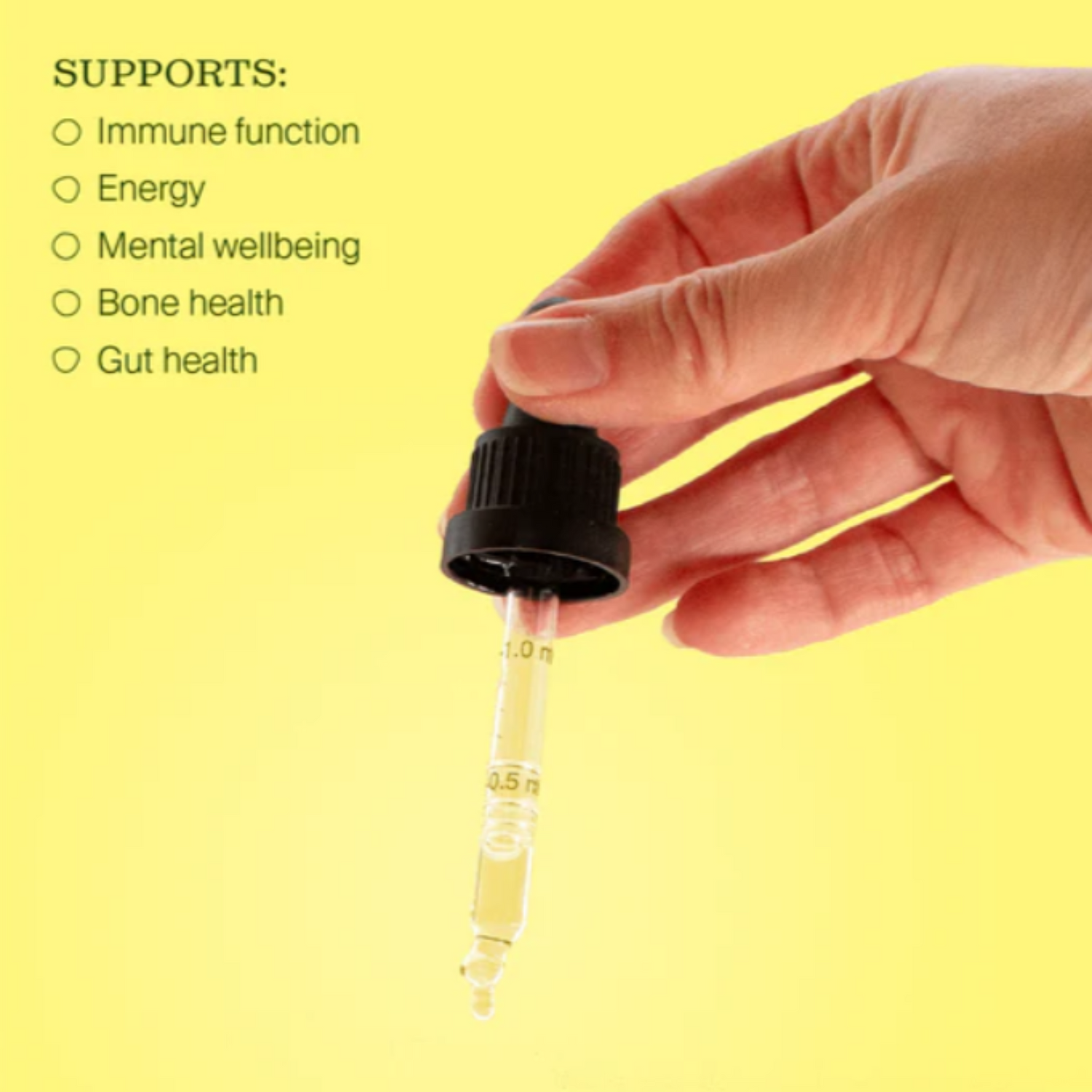 Hand holding a dropper with liquid vitamin d against a yellow background, listing health benefits.