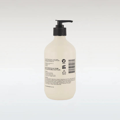 Beige bottle with black pump on a white background