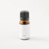 Small amber glass bottle of AIR essential oil blend on white bench.