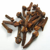 Small pile of cloves on white surface. 