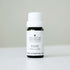 Small bottle of rose essential oil on white bench with soft grey background. 