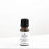 Small amber glass bottle of cinnamon essential oil on white bench. 