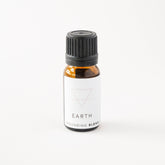 Small amber glass bottle of earth essential oil blend. 