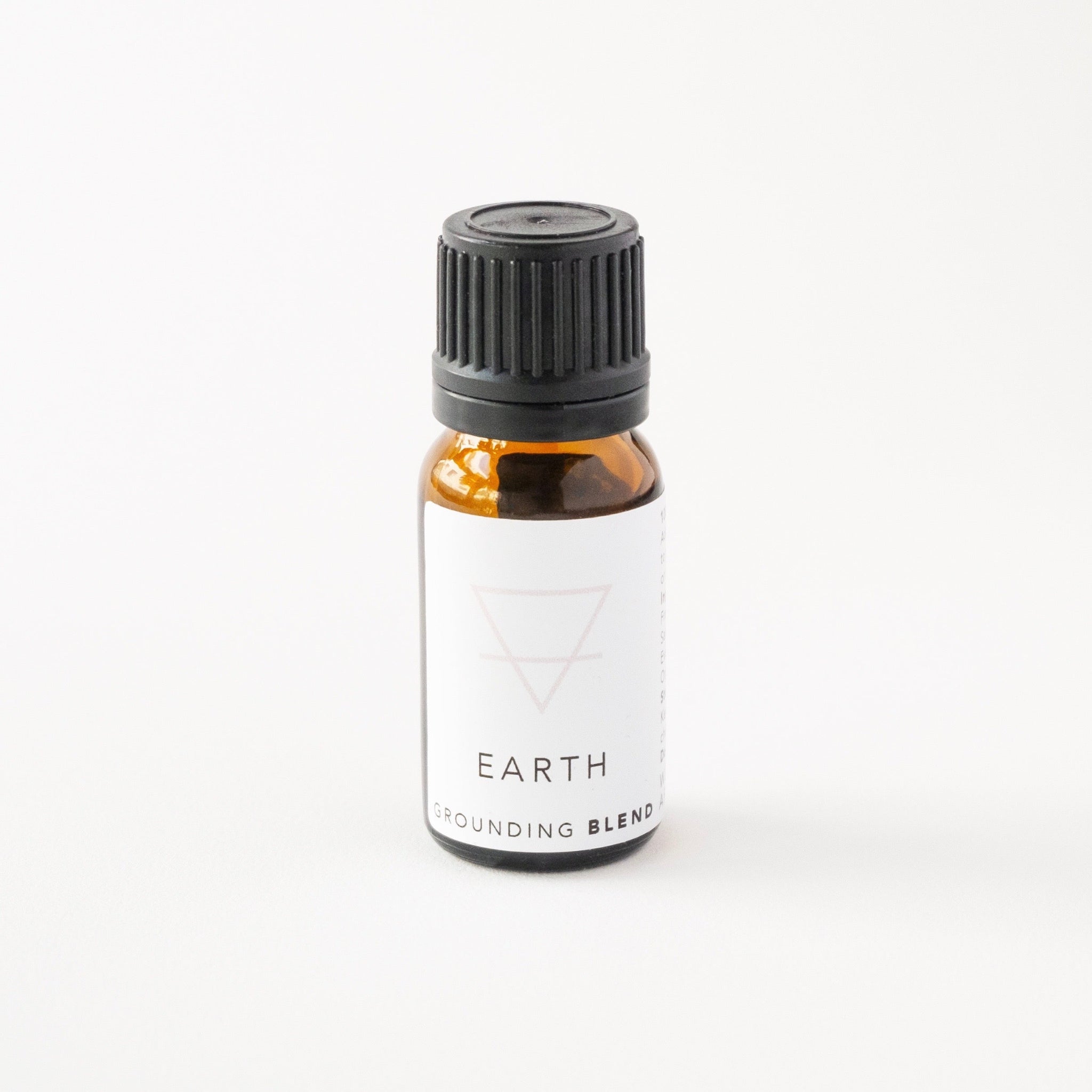 Small amber glass bottle of earth essential oil blend. 
