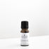 Small amber glass bottle of geranium essential oil on white bench. 