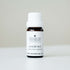 Small bottle of Jasmine essential oil on white bench with soft grey background. 