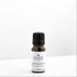 Small amber glass bottle of lemongrass essential oil on white bench. 