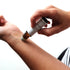 A small amber glass perfume bottle of Lunar blend being rolled onto a wrist. 