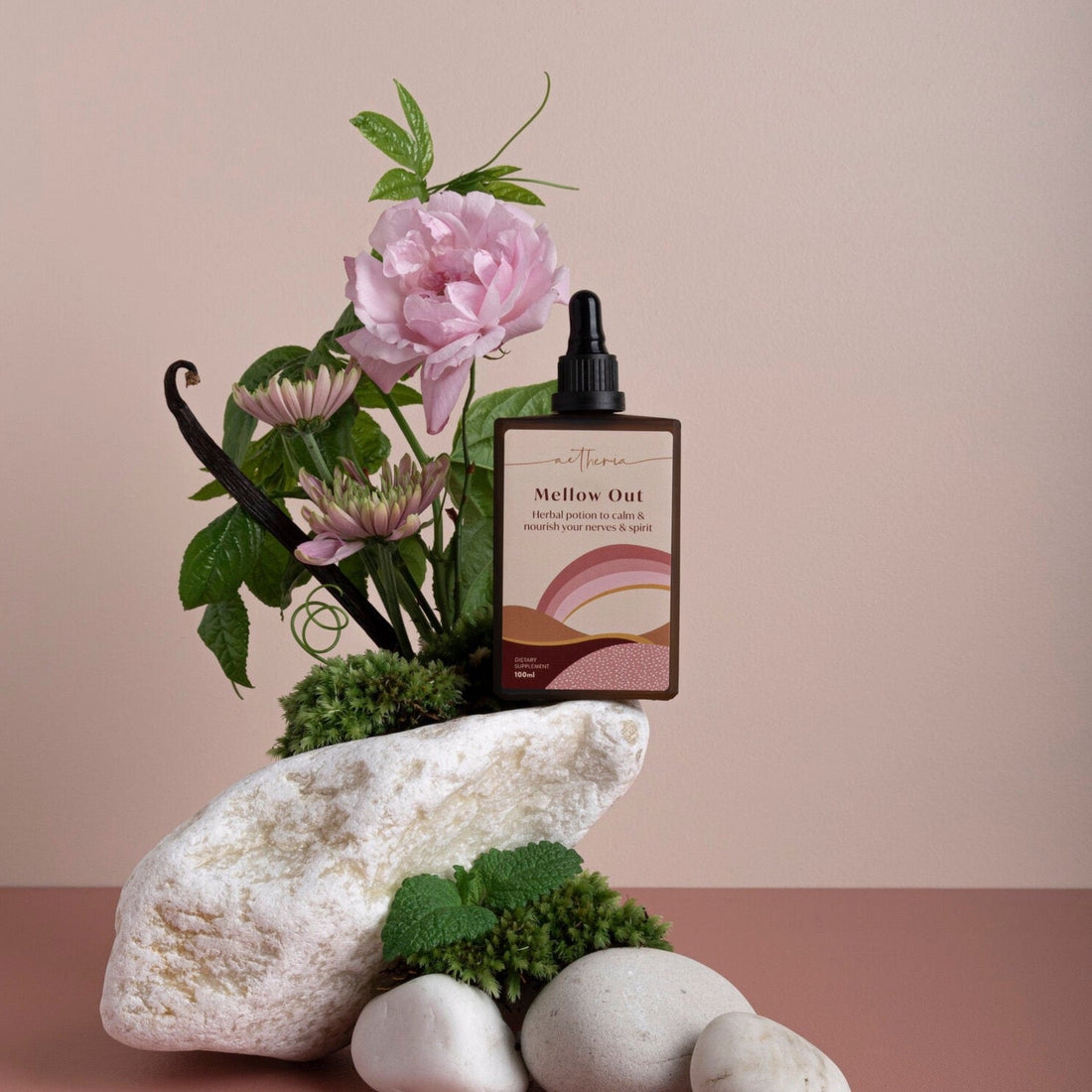 A bottle of Mellow Out tonic displayed with some of its plant ingredients. 