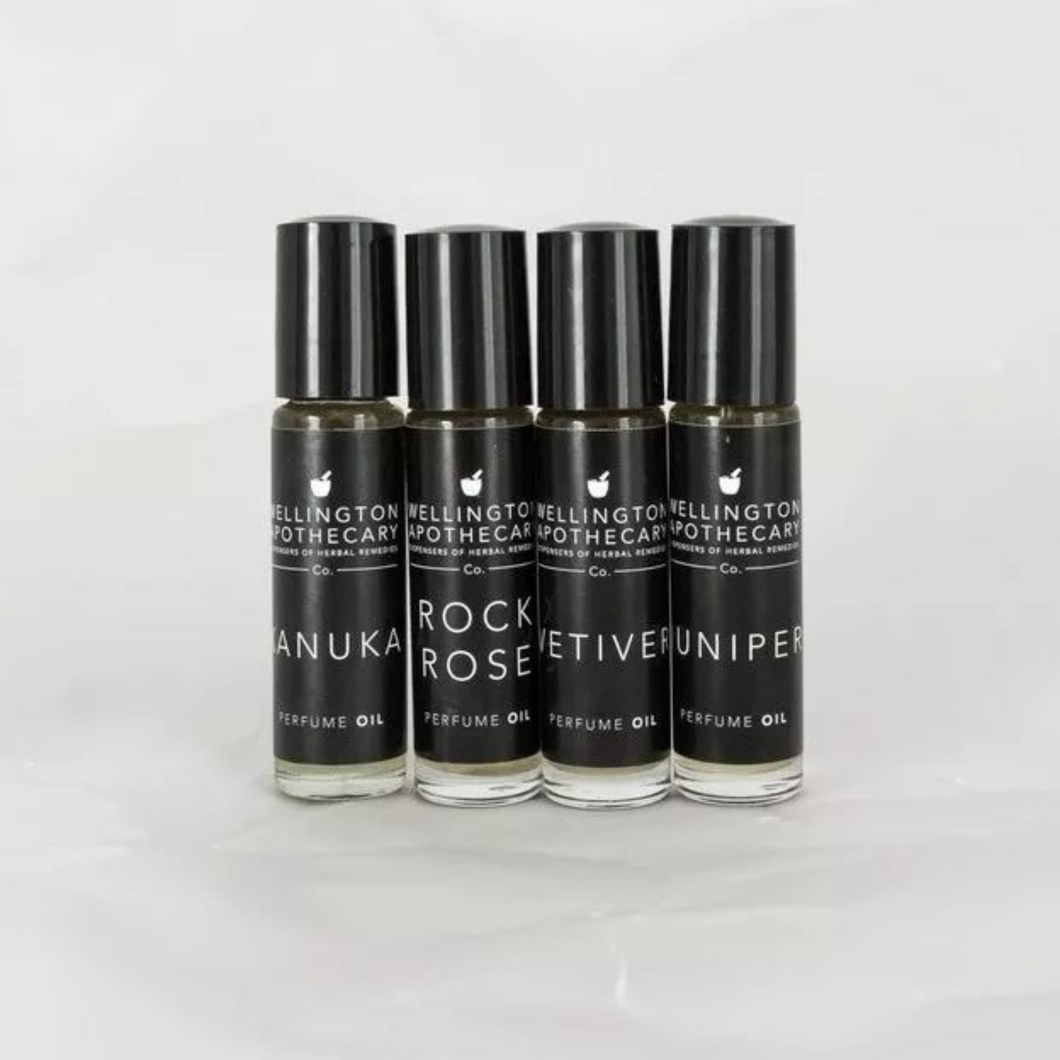 Four glass bottles with black labels containing our perfume oil blends. 