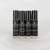 Four glass bottles with black labels containing our perfume oil blends. 
