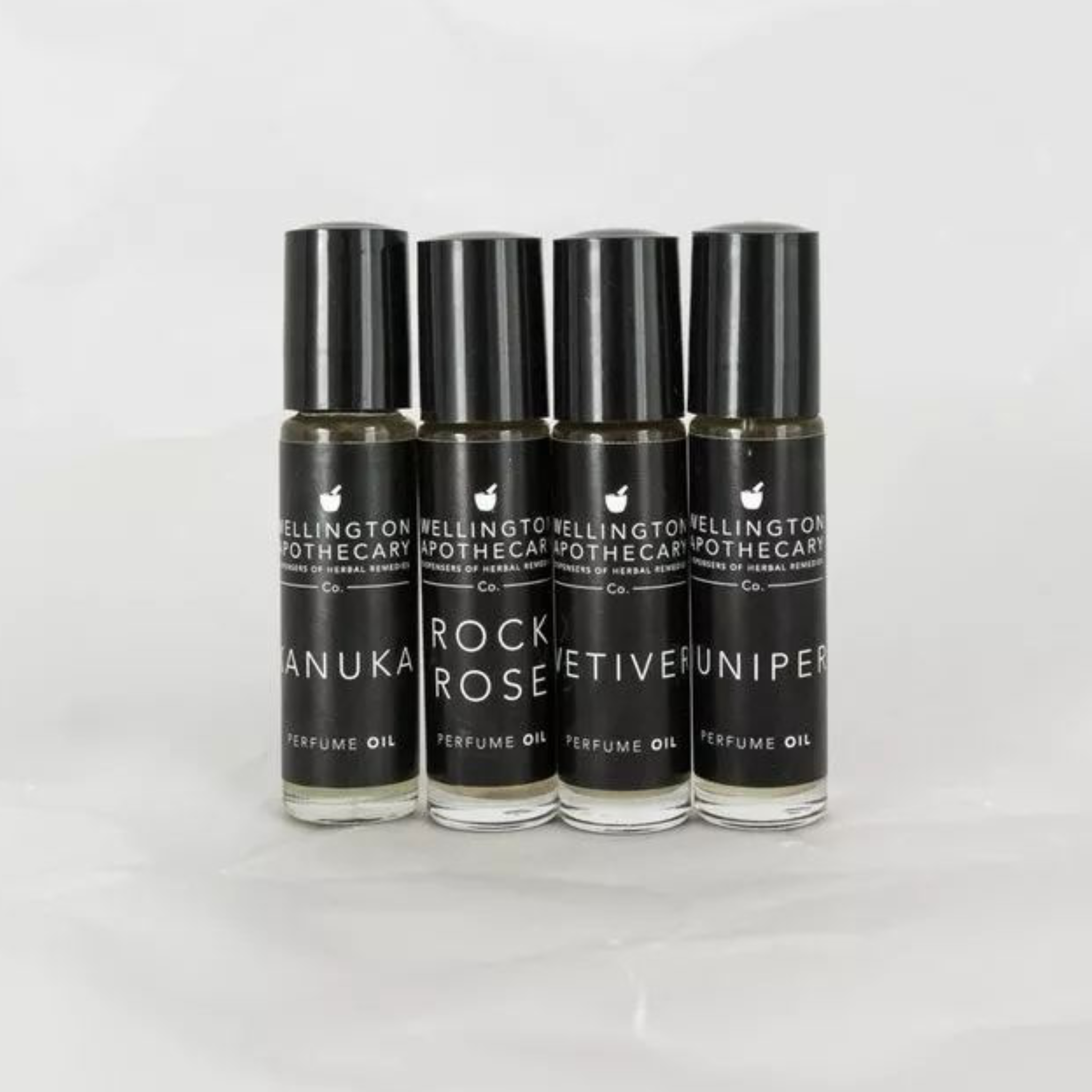 Four glass bottles with black labels containing our perfume oil blends. 
