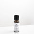 Small amber glass bottle of rosemary essential oil on white bench. 