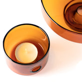 A close up of the amber glass oil burner and tea light candle by Studio Milligram. 