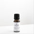 Small amber glass bottle of Ylangylang essential oil on a white bench. 